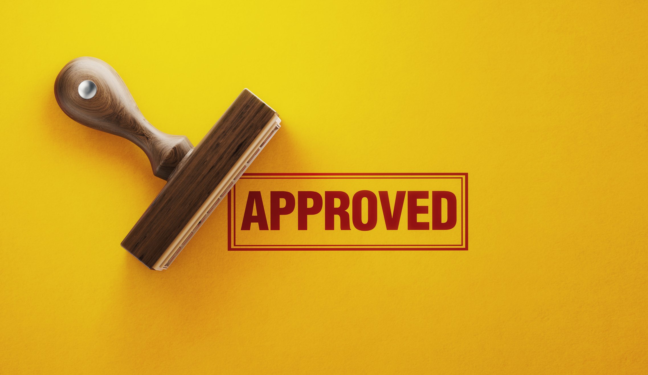 An APPROVED rubber stamp on a yellow background
