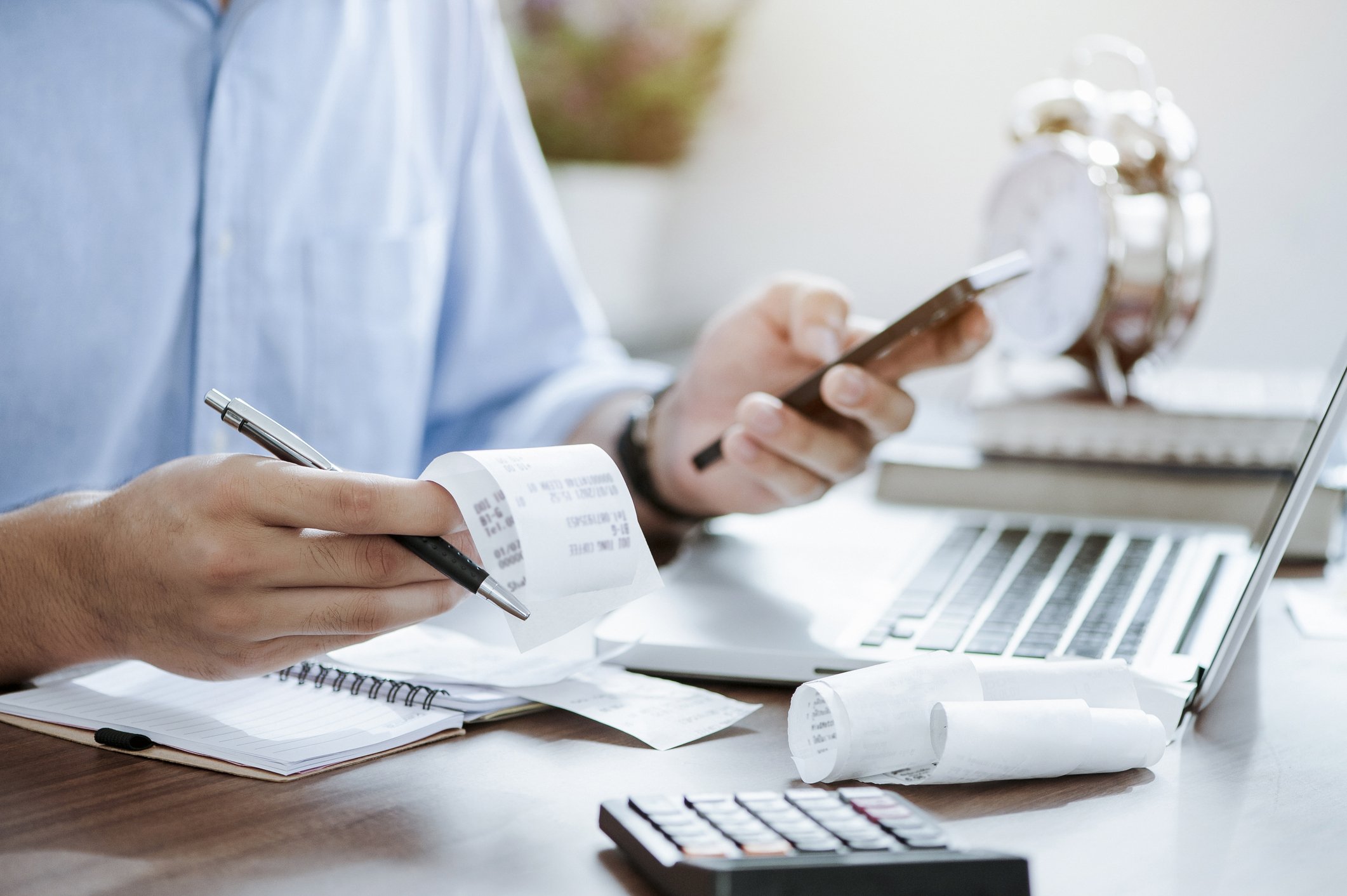 Person calculating extension costs at a desk with a calculator