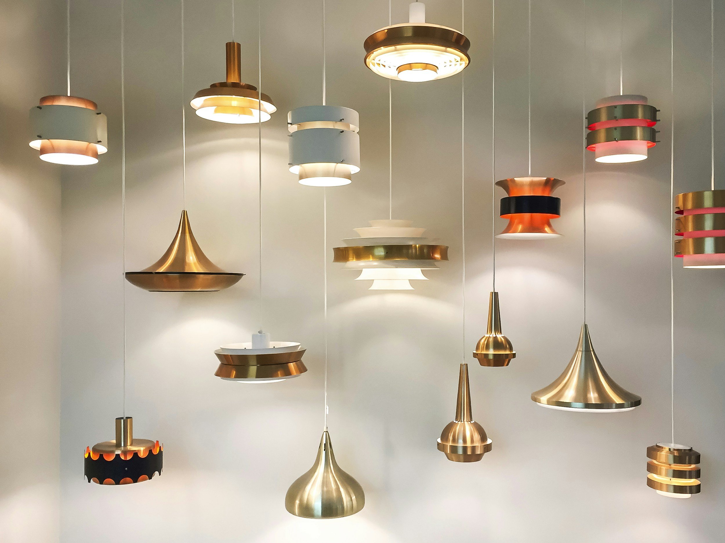 A collection of modern pendant lights in gold, white, and red