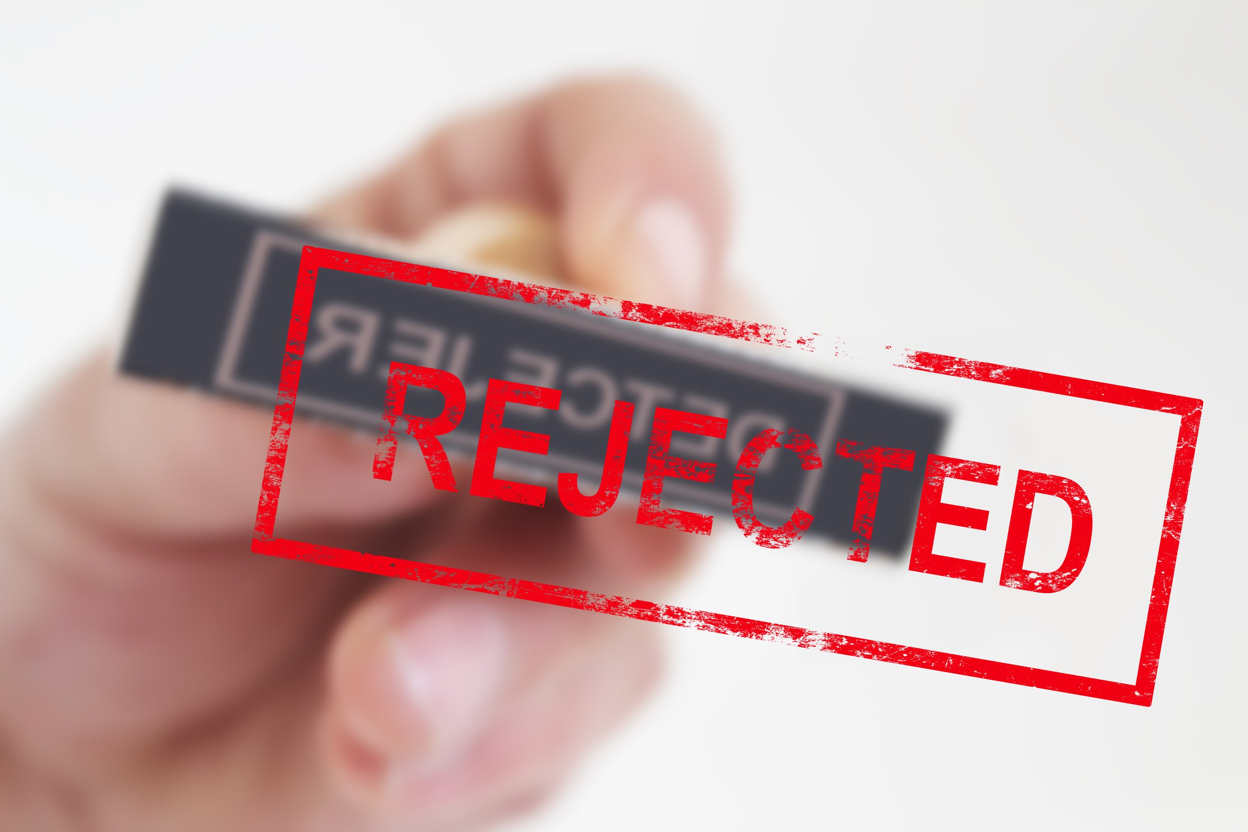 Red REJECTED stamp over a blurred document