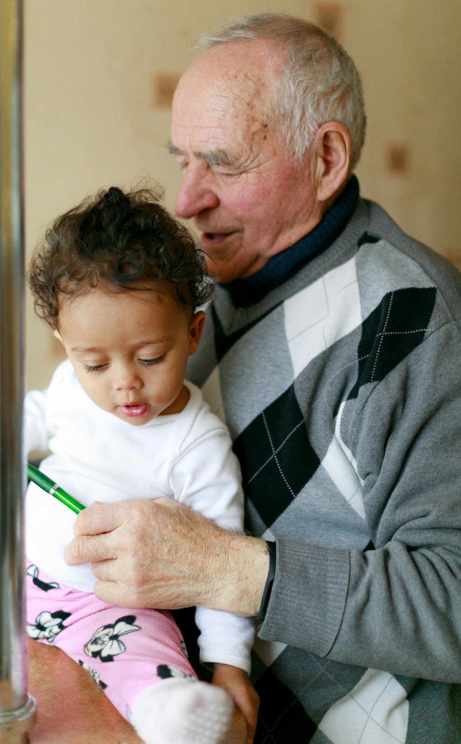 Elderly man and child drawing together at a table