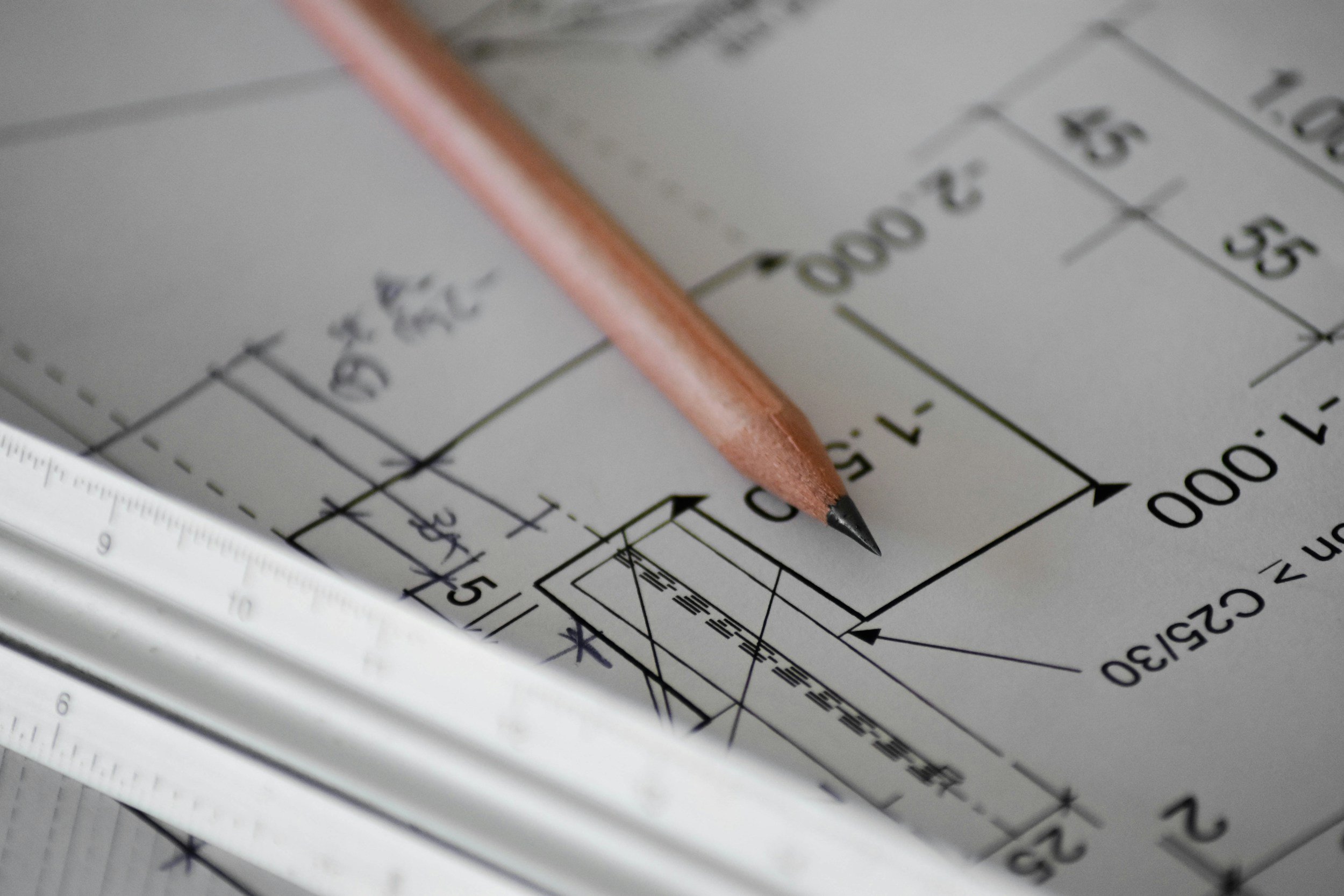 Architectural blueprints and a pencil