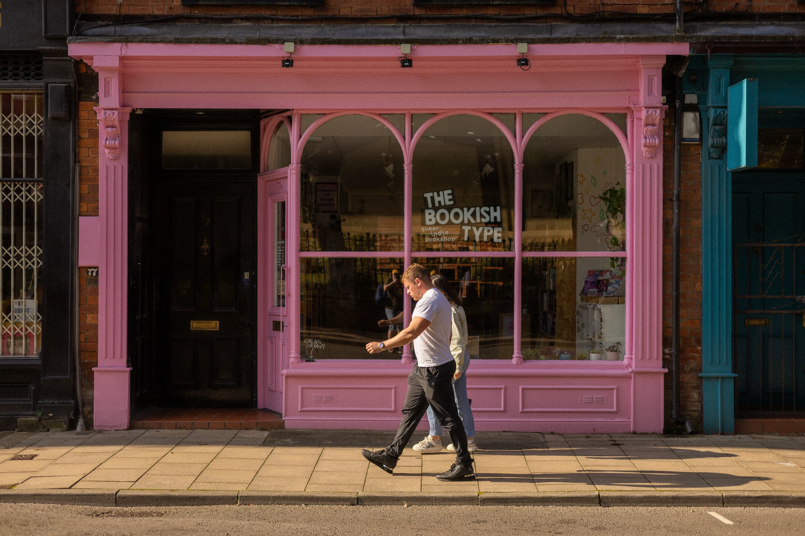 A pink-painted traditional shopfront on a London high street with arched windows